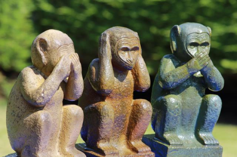 Trio of "see no evil", "hear no evil", and "speak no evil" monkey statues.