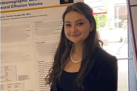 Altea Thompson is smiling at the camera while posing by a science presentation board